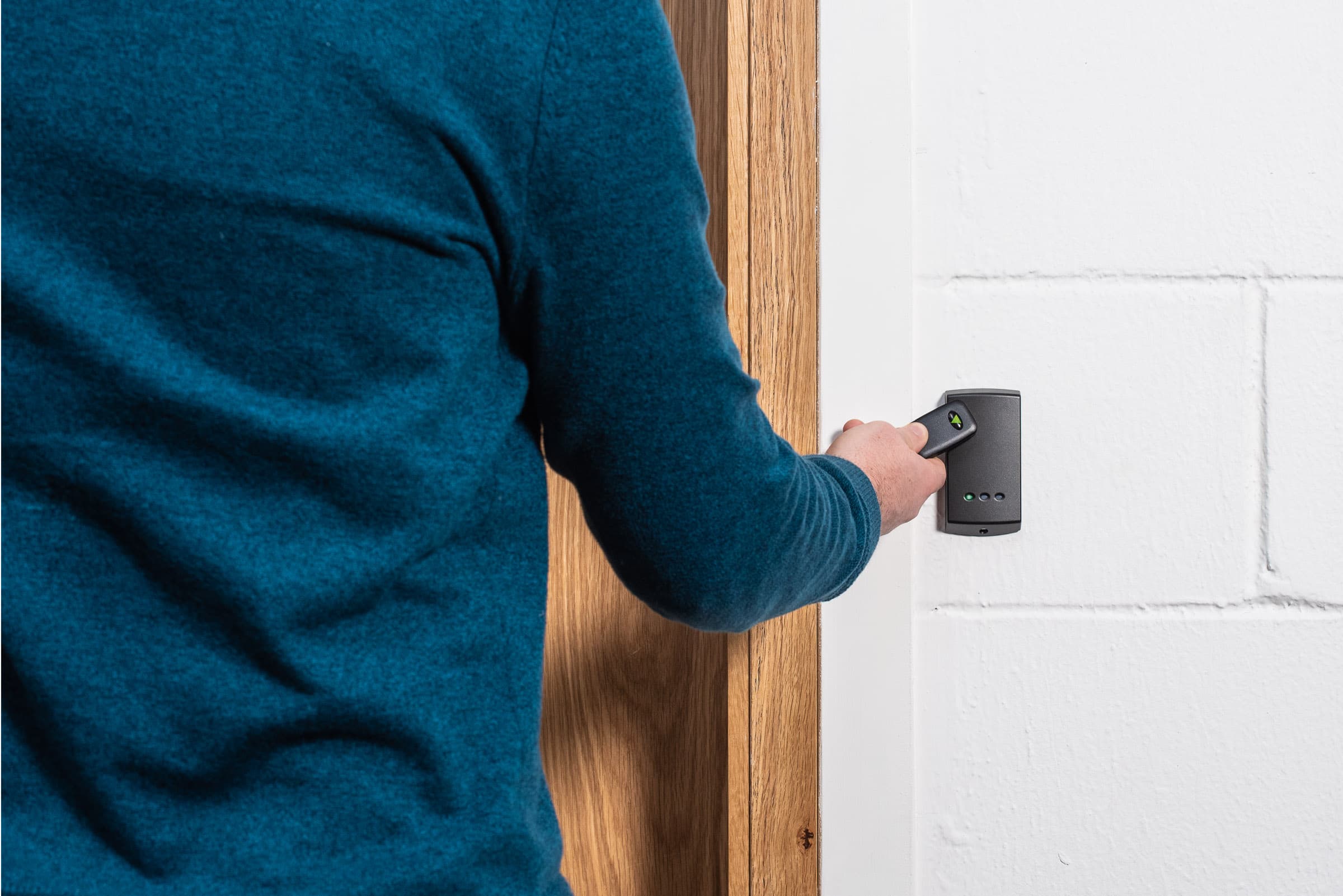 A Paxton proximity reader mounted beside a door, with a fob presented to it